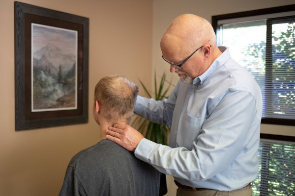 Dr. Carl Beukelman performing a gentle chiropractic adjustment on a patient